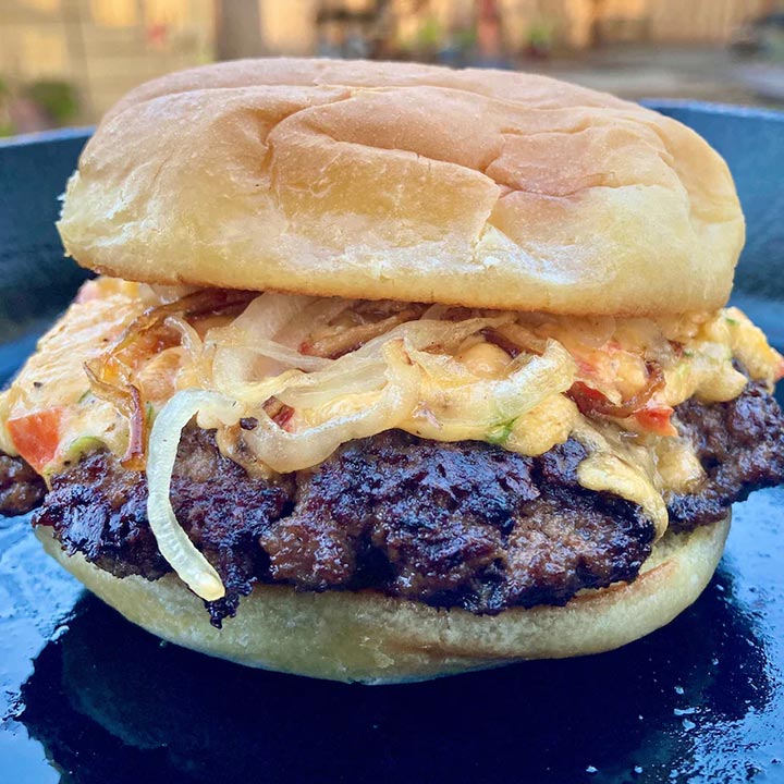 Juicy buffalo burger with melted cheese, peppers and onions